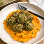 Gluten Free Sage Chicken Meatballs with Sweet Potato Carrot Mash on white plate with black fork
