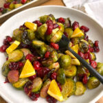 Roasted Brussels Sprouts with Cranberries on white plate with black fork