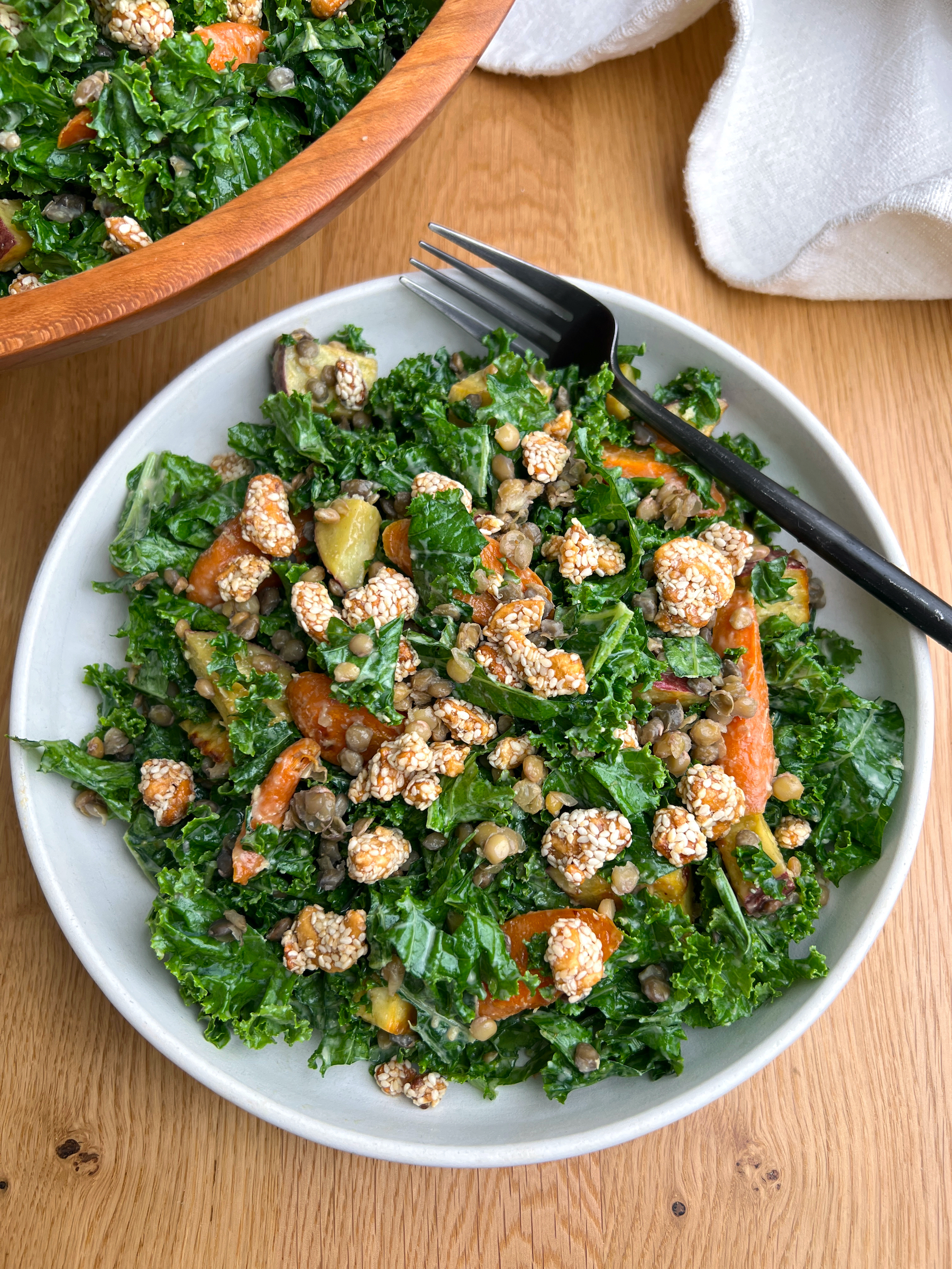 Kale Salad with Miso Tahini Dressing in White Bowl with Black Fork