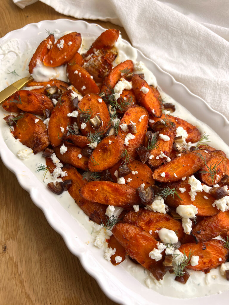 Harissa Maple Carrots with Whipped Feta on White Platter with Gold Serving Spoon