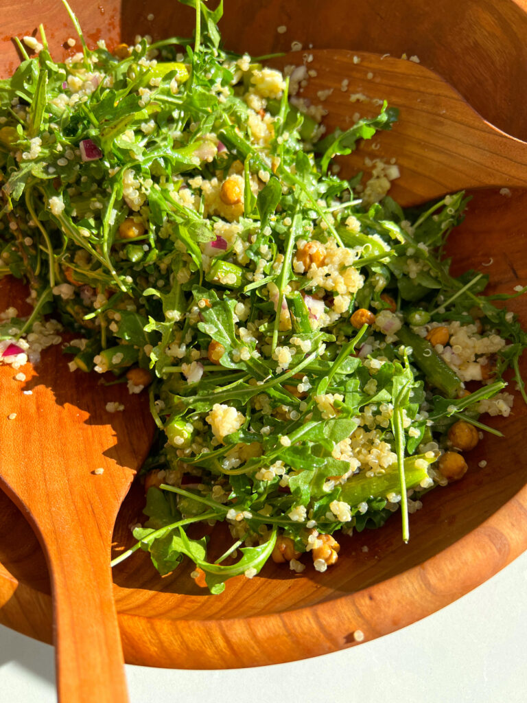 Spring Arugula and Quinoa Salad with Lemon Dressing in salad bowl with tongs