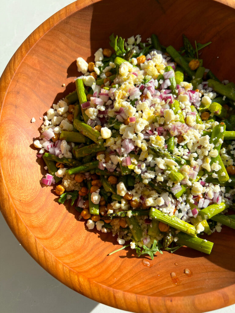 Spring Arugula and Quinoa Salad with Lemon Dressing in salad bowl before being tossed