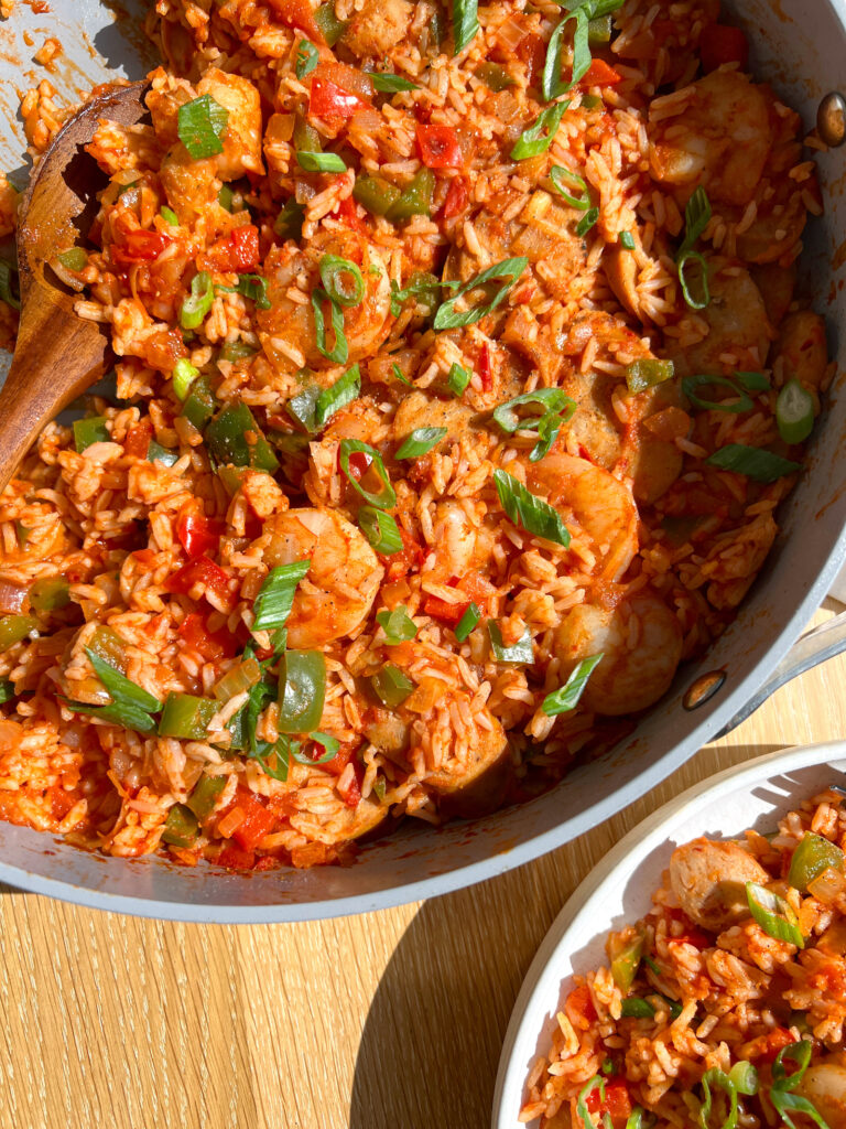 15-Minute Healthy Jambalaya Recipe in pan with spatula and plate in the corner