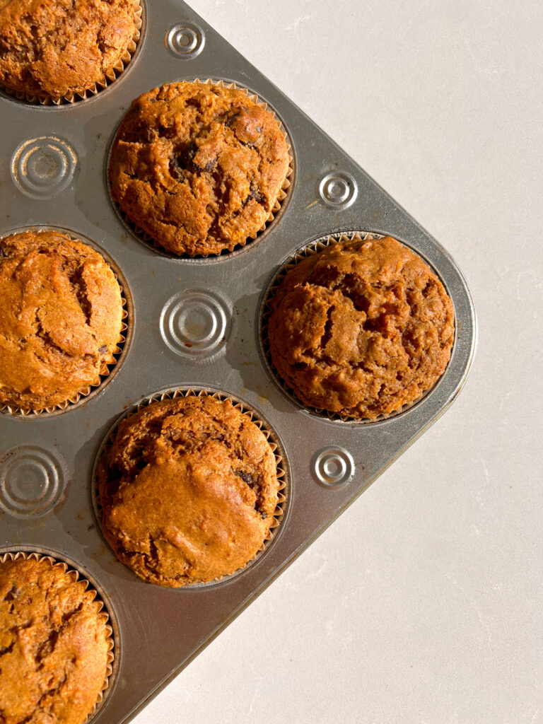 Gluten Free Carrot Cake Muffins with Chocolate Chips in muffin tin after being bakedGluten Free Carrot Cake Muffins with Chocolate Chips in muffin tin after being baked