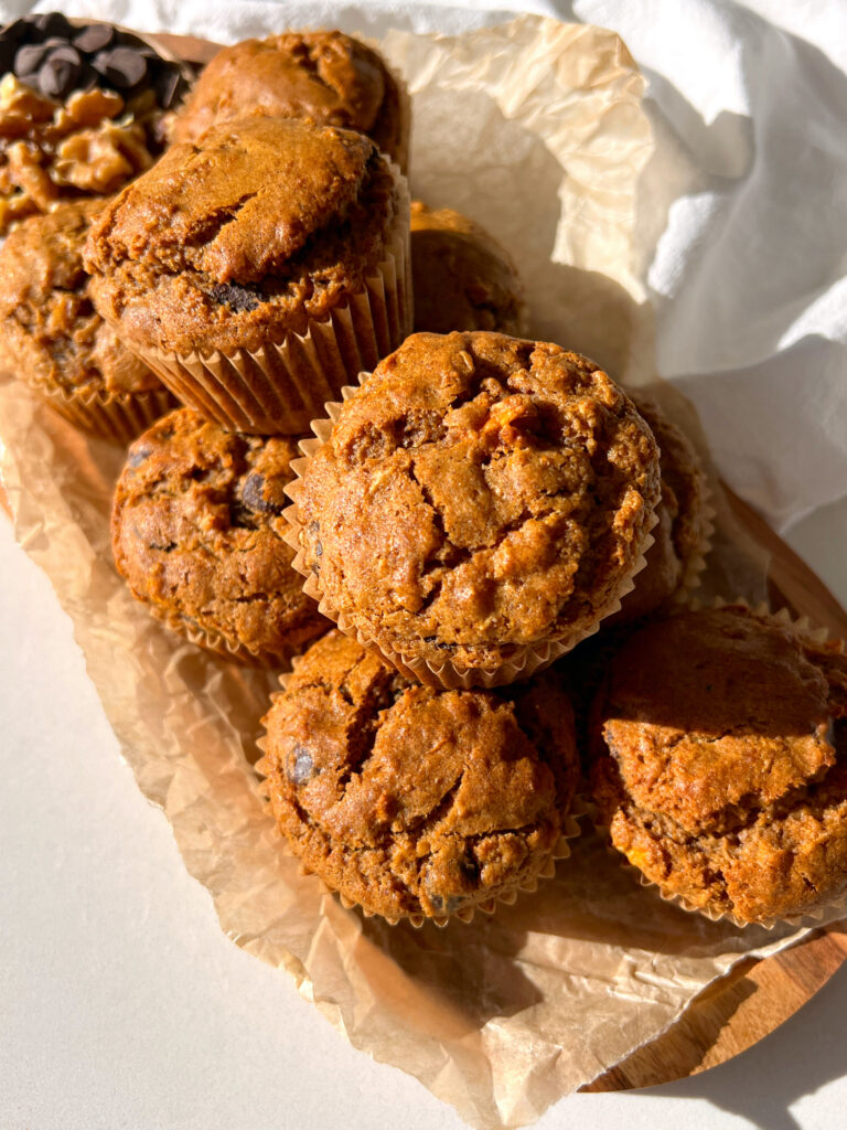 Gluten Free Carrot Cake Muffins with Chocolate Chips stacked on top of each other