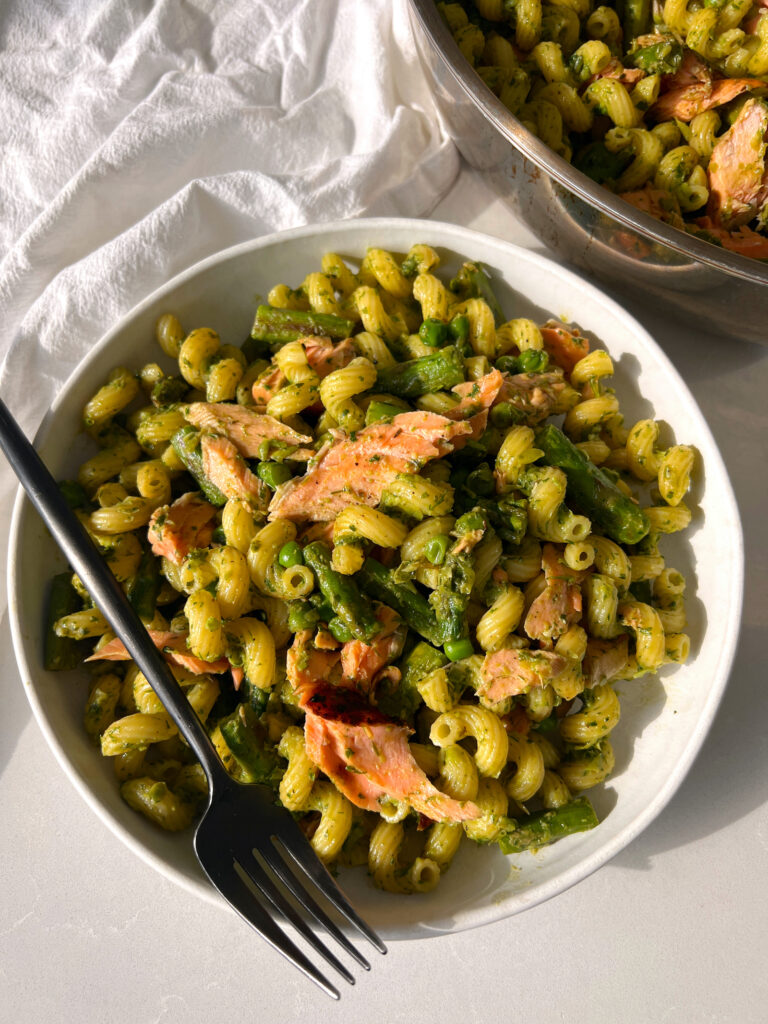 Salmon Pea Pasta with Asparagus on White Plate with Black Fork and Pan in Background