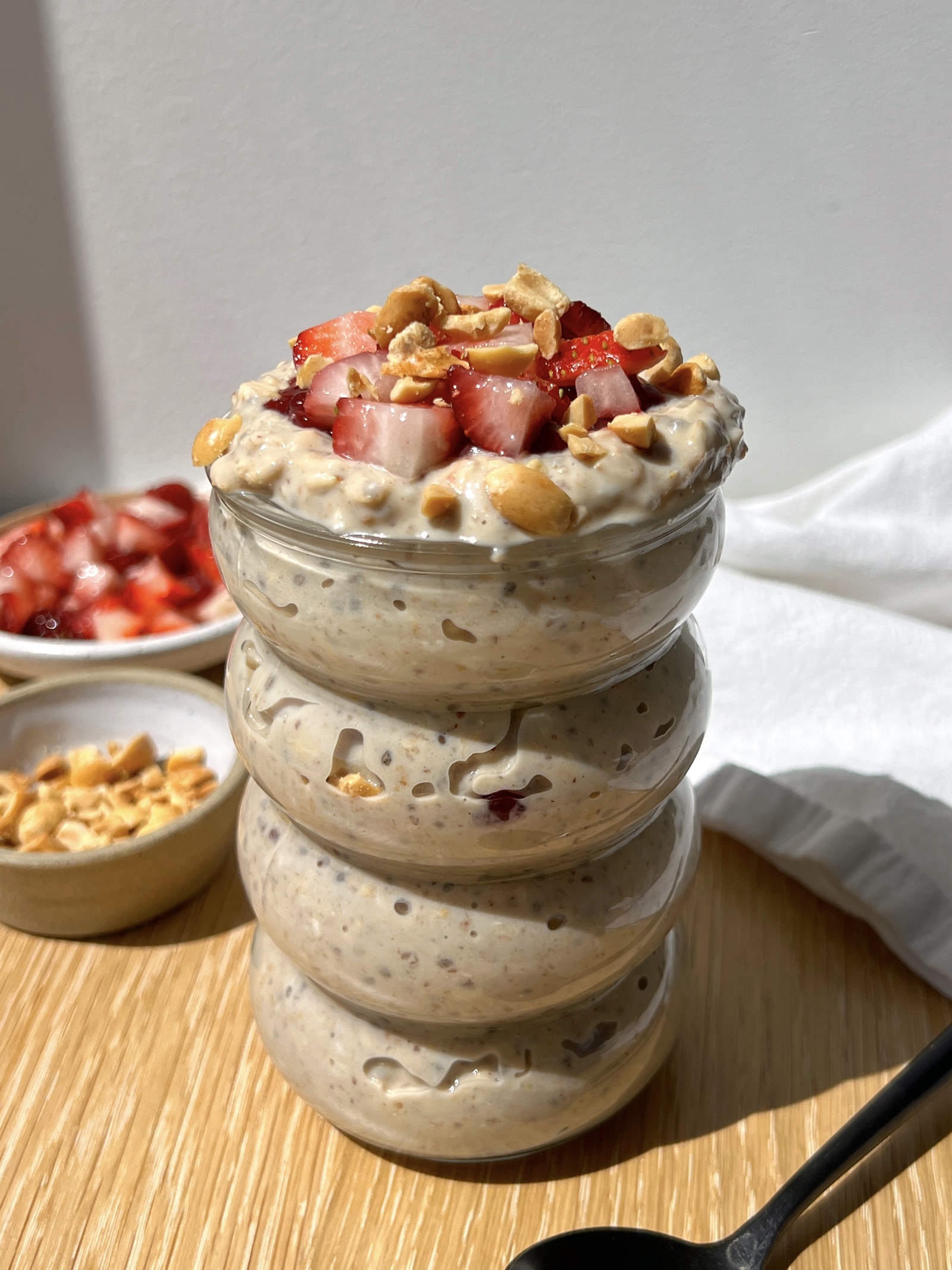 high-protein peanut butter and jelly overnight oats in a glass jar topped with strawberries and peanuts